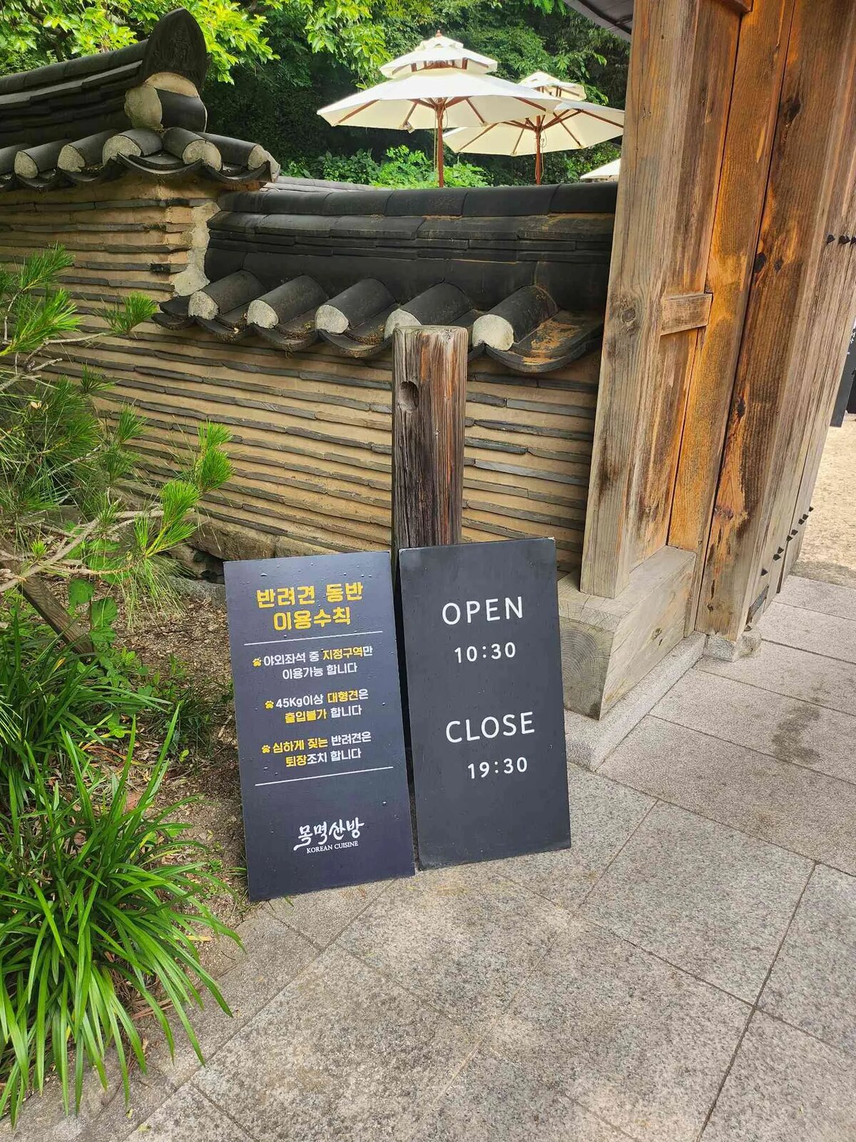 목멱산방 한옥 대문과 돌담, 야외 테이블 우산들