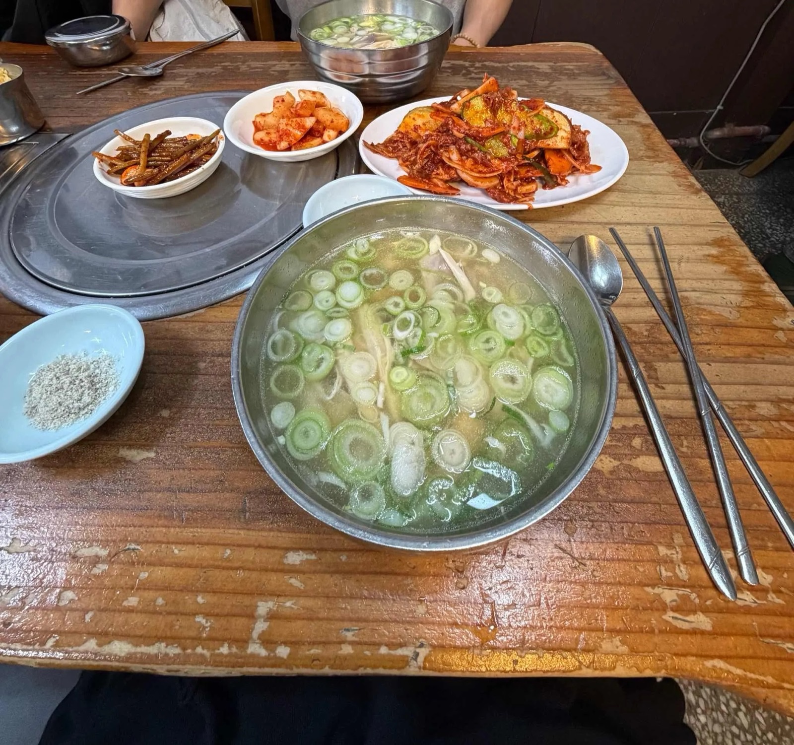나무 테이블 위 닭곰탕과 반찬들